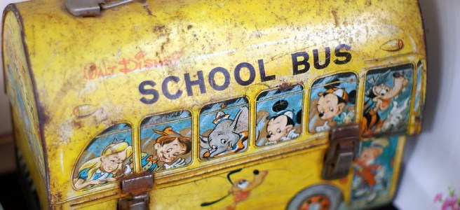 yellow tin lunch box illustrated as a school bus